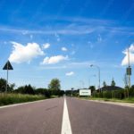 Blue sky white clouds road signs street lamps background image & Google Slides Theme