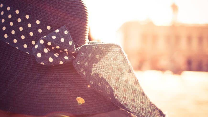 Navy Polka Dot Bow Tie and Straw Hat Warm Tones background image