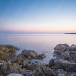 Pale Blue Pink Sky Rocks Shoreline background image & Google Slides Theme