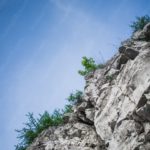 Pale Blue Sky Grey Rock Formation Green Foliage background image & Google Slides Theme