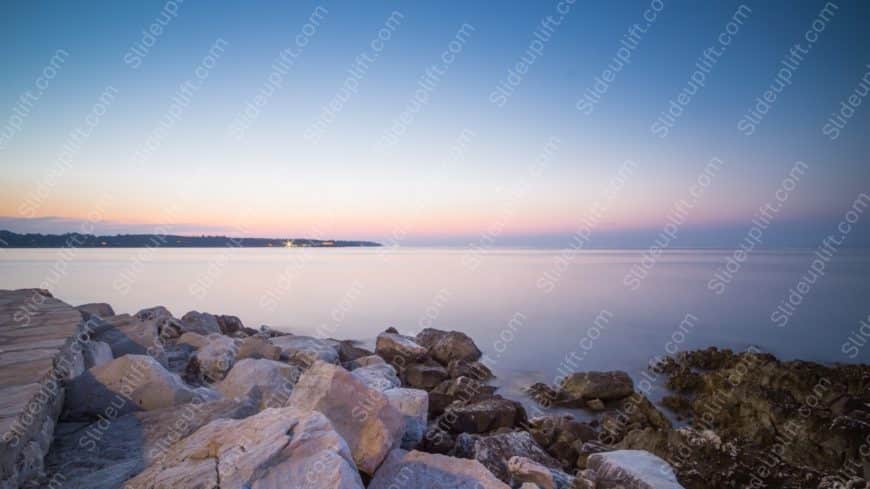 Pastel Pink Blue Sky Rocks Shoreline background image