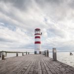 Red White Lighthouse Wooden Pier Dramatic Sky background image & Google Slides Theme