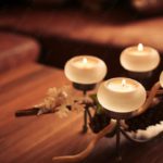 Warm white candles and pinecone on table background image & Google Slides Theme