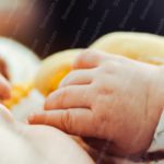 Peach Cream Baby Hand on Yellow Blanket background image & Google Slides Theme