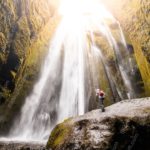 Sunlit GreenCliff Waterfall Hiker background image & Google Slides Theme