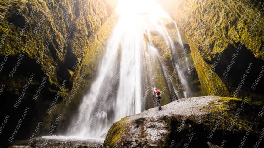 Sunlit GreenCliff Waterfall Hiker background image