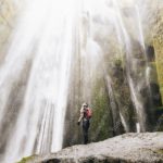 Green Mossy Waterfall And Person Background Image & Google Slides Theme