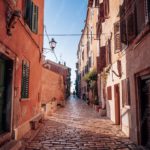 Orange Terracotta Buildings Cobblestone Street Background Image & Google Slides Theme