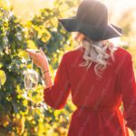 Red Dress Woman Holding Wineglass Green Vineyard Background Image & Google Slides Theme