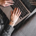 Silver Laptop On Gray Couch Background Image & Google Slides Theme