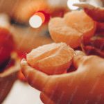 Warm Orange Peeled Fruit Hands Background Image & Google Slides Theme