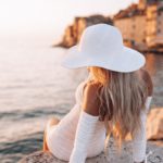 White Hat Woman Creamy Dress Seaside Town Background Image & Google Slides Theme